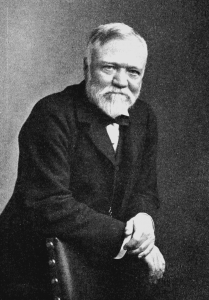 black and white photo of Andrew Carnegie, leaning against the back of a chair